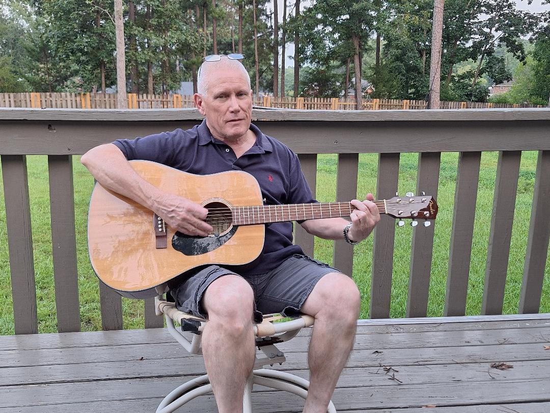 Jeff Lokken playing guitar on his deck